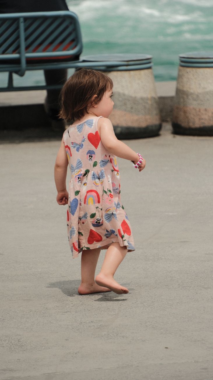 Toddler walking barefoot outdoors mid-stride